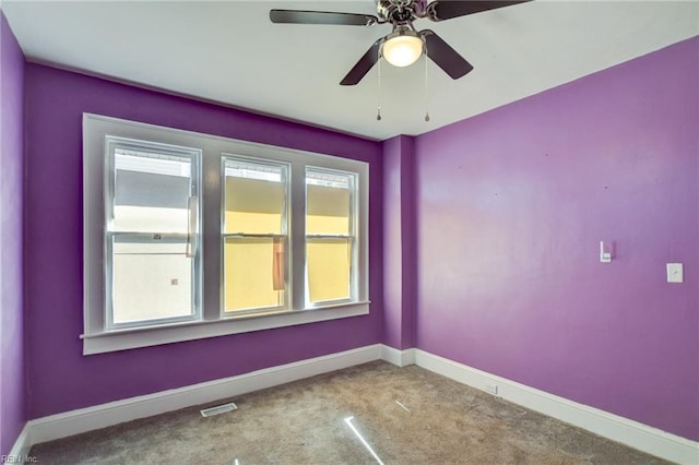 unfurnished room featuring carpet floors, visible vents, and baseboards