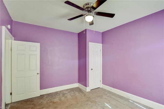 empty room with carpet floors, baseboards, and a ceiling fan