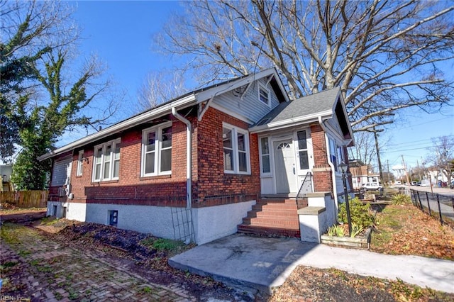 view of front facade with fence and brick siding