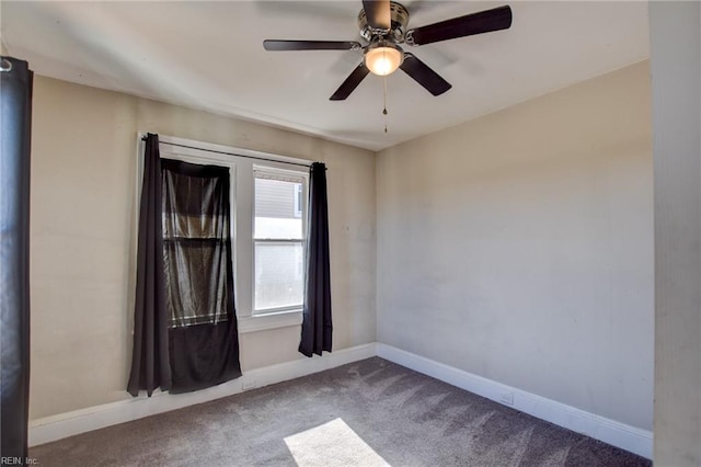 carpeted empty room featuring ceiling fan and baseboards