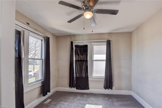 unfurnished room featuring carpet floors, plenty of natural light, visible vents, and baseboards