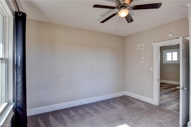 carpeted empty room featuring a ceiling fan and baseboards