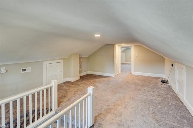 bonus room featuring lofted ceiling, carpet floors, visible vents, and baseboards