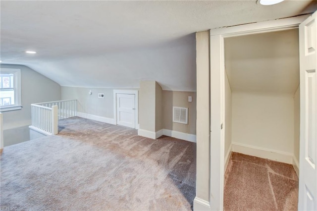 additional living space with lofted ceiling, baseboards, visible vents, and carpet flooring