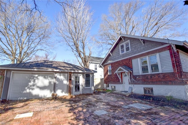 view of front facade featuring a garage, brick siding, and an outdoor structure