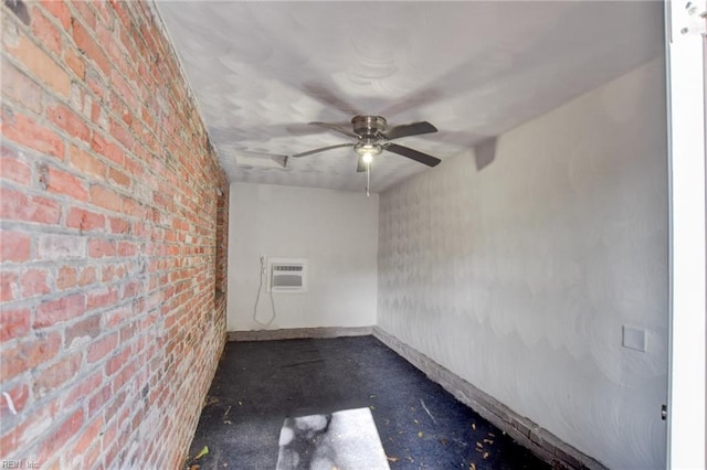 spare room with brick wall, a ceiling fan, and a wall mounted AC