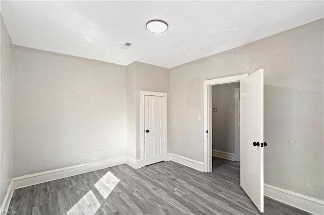 spare room featuring baseboards and wood finished floors