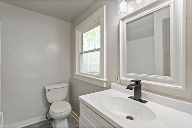 bathroom featuring wood finished floors, vanity, toilet, and baseboards