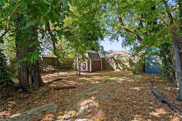 view of yard with an outbuilding, a fenced backyard, and a storage shed