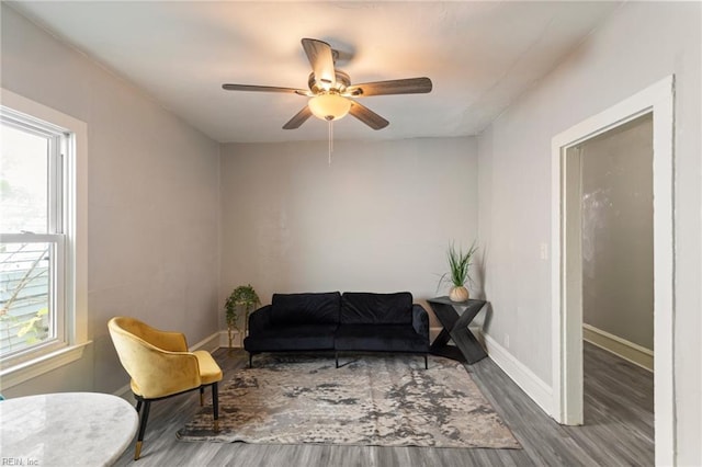 sitting room with ceiling fan, baseboards, and wood finished floors