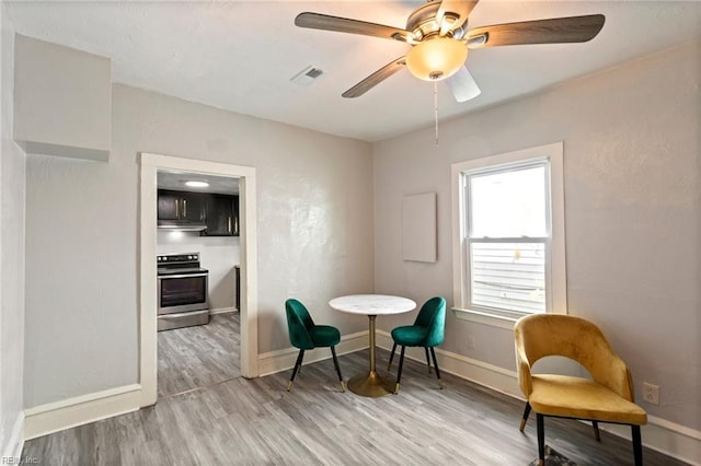 living area with a ceiling fan, baseboards, visible vents, and wood finished floors