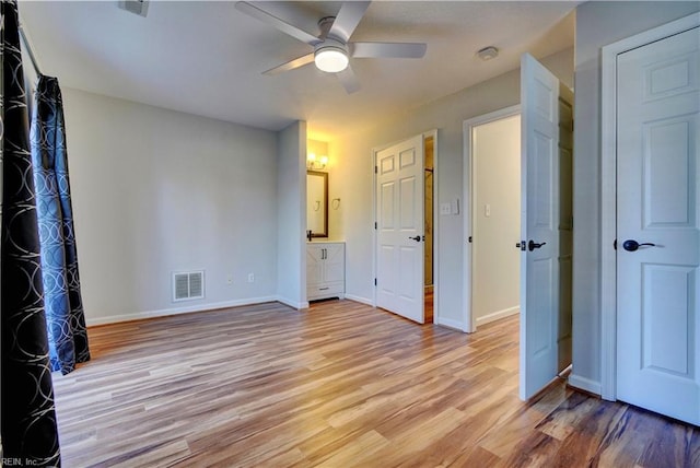 unfurnished bedroom with light wood-type flooring, baseboards, visible vents, and ensuite bathroom