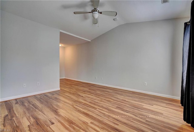 spare room featuring lofted ceiling, ceiling fan, baseboards, and light wood-style floors