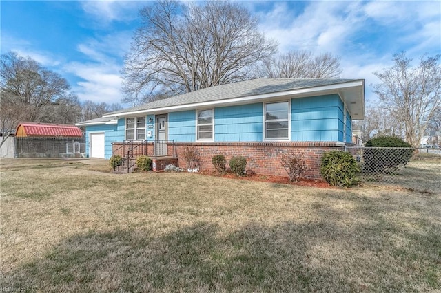 ranch-style home featuring a front yard, brick siding, fence, and an attached garage