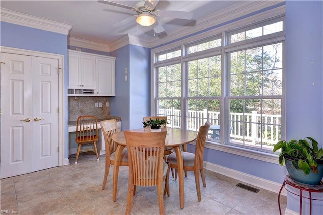 dining space featuring light tile patterned flooring, a ceiling fan, visible vents, baseboards, and ornamental molding