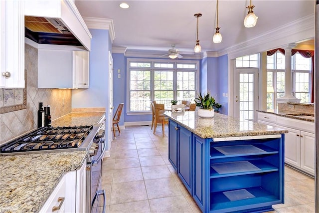 kitchen featuring blue cabinets, premium range hood, ornamental molding, stainless steel range with gas cooktop, and open shelves