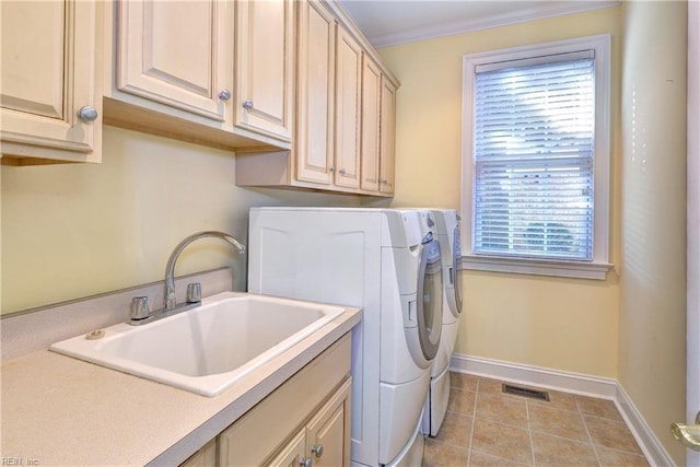 clothes washing area featuring cabinet space, baseboards, visible vents, independent washer and dryer, and a sink