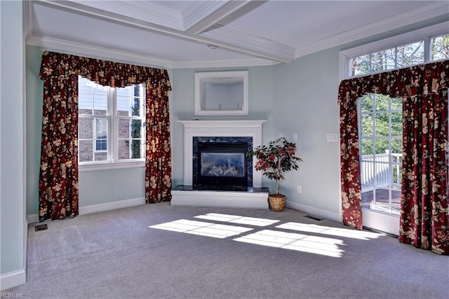 unfurnished living room featuring a wealth of natural light, a fireplace, crown molding, and carpet flooring