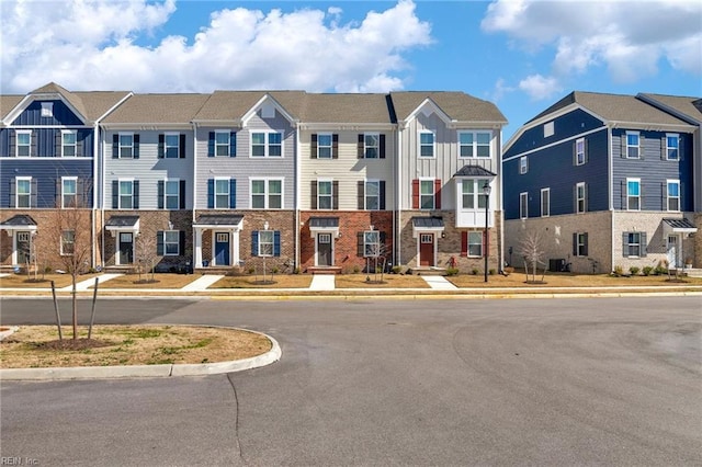 multi unit property with a residential view, board and batten siding, and brick siding