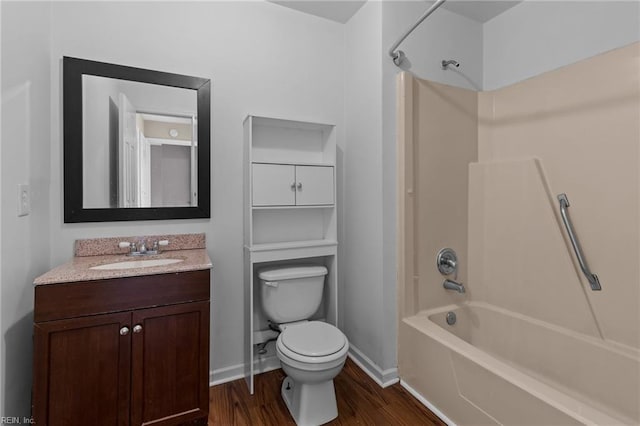 bathroom featuring toilet, vanity, shower / tub combination, wood finished floors, and baseboards