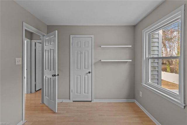 unfurnished bedroom featuring light wood finished floors and baseboards