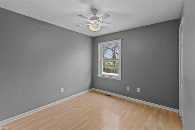 spare room with ceiling fan, wood finished floors, and baseboards