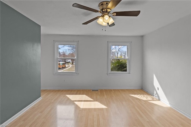 spare room with ceiling fan, baseboards, and wood finished floors