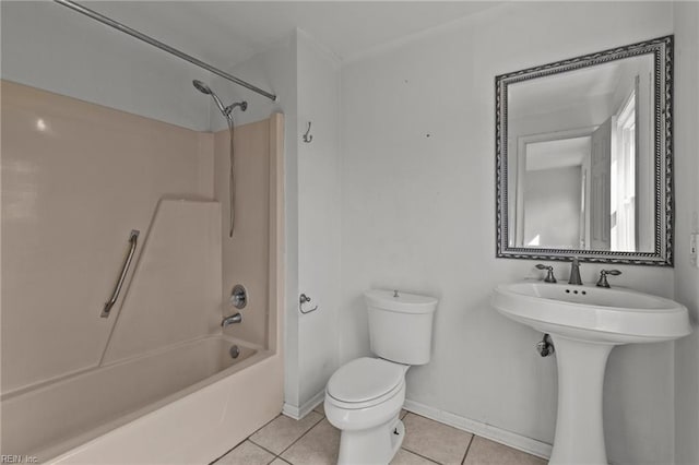 bathroom featuring toilet, washtub / shower combination, a sink, baseboards, and tile patterned floors