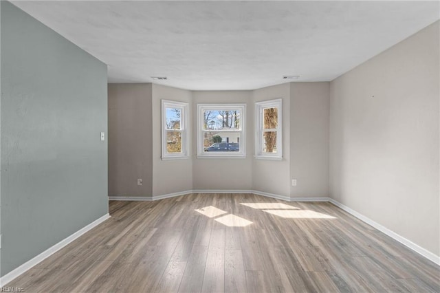 empty room with baseboards and wood finished floors