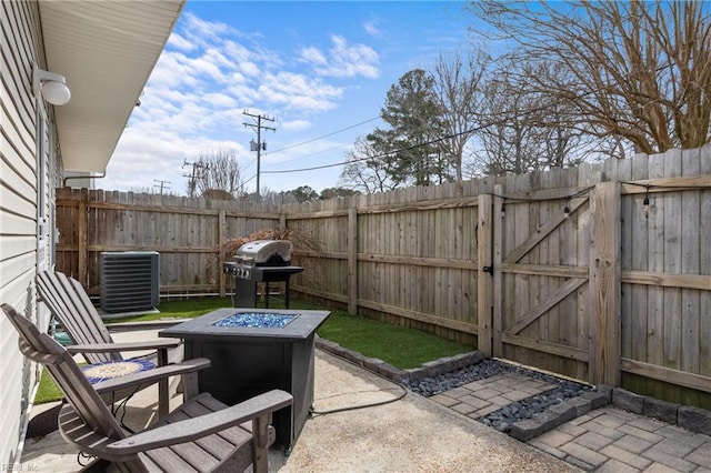 view of patio with area for grilling, an outdoor fire pit, a gate, fence, and cooling unit