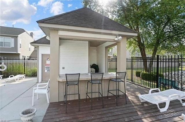 wooden deck with fence, outdoor dry bar, and a gazebo