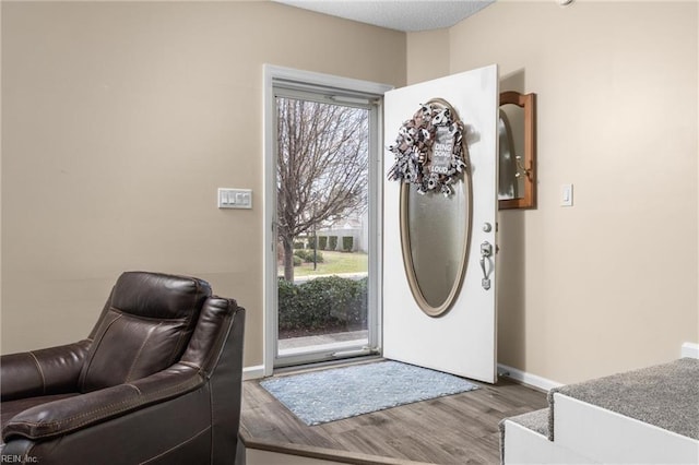 foyer featuring baseboards and wood finished floors