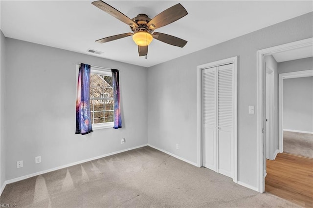 unfurnished bedroom with a closet, visible vents, carpet flooring, ceiling fan, and baseboards