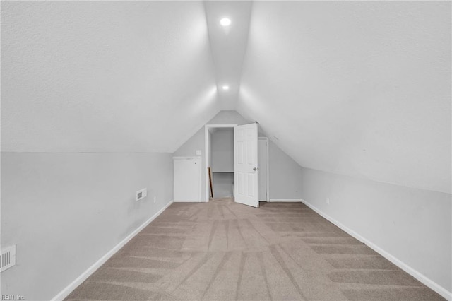 bonus room featuring lofted ceiling, a textured ceiling, baseboards, and carpet flooring