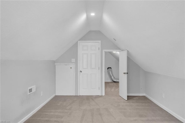 bonus room featuring lofted ceiling, a textured ceiling, carpet flooring, and baseboards