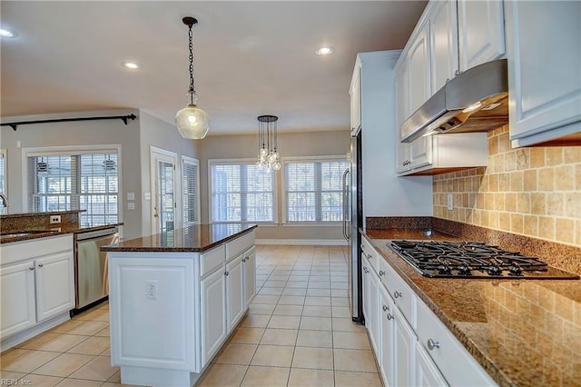 kitchen featuring black gas cooktop, decorative backsplash, a kitchen island, dishwasher, and under cabinet range hood