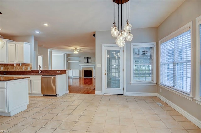 kitchen with light tile patterned floors, ceiling fan, open floor plan, and dishwasher