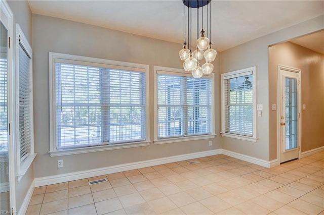 unfurnished dining area with baseboards, visible vents, and tile patterned floors