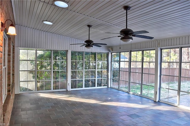 unfurnished sunroom with a ceiling fan