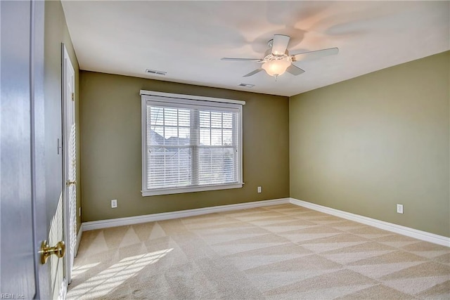 spare room featuring a ceiling fan, carpet, visible vents, and baseboards