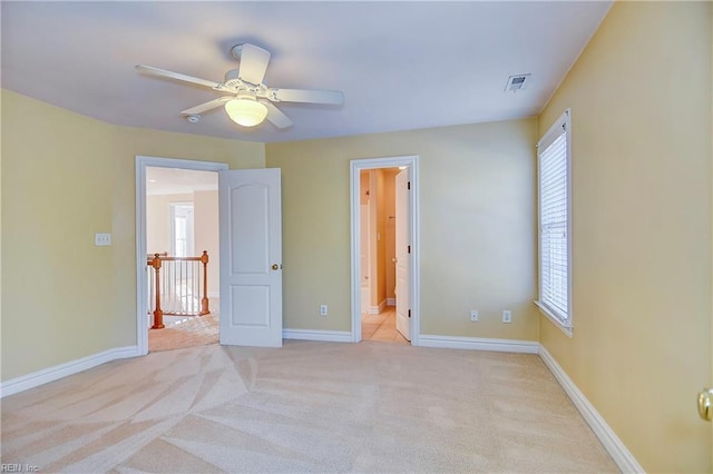 unfurnished bedroom featuring light carpet, baseboards, multiple windows, and visible vents