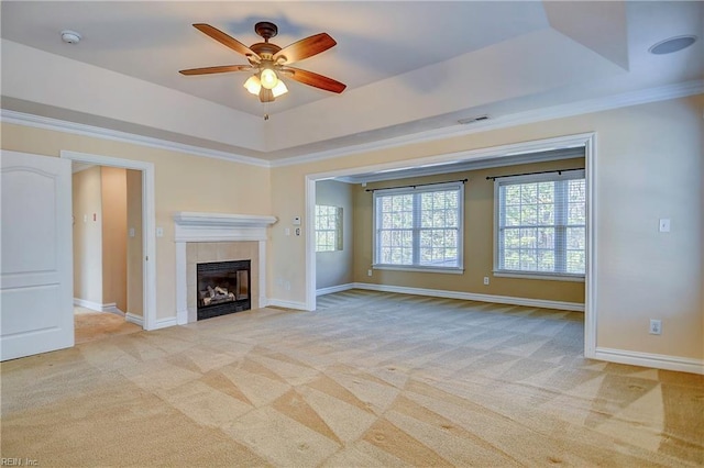 unfurnished living room with light carpet, visible vents, baseboards, a raised ceiling, and ornamental molding