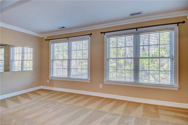 unfurnished room featuring baseboards, carpet flooring, visible vents, and crown molding