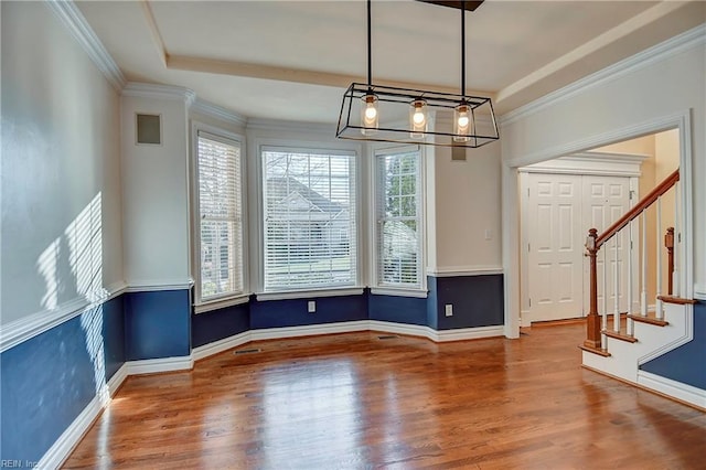 unfurnished dining area with stairs, baseboards, wood finished floors, and crown molding