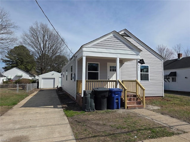 view of front of home featuring covered porch, a garage, an outdoor structure, fence, and driveway