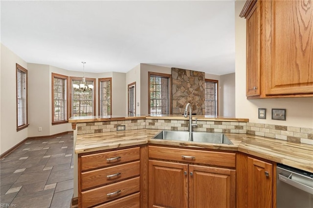 kitchen with a peninsula, a sink, wood counters, dishwasher, and tasteful backsplash