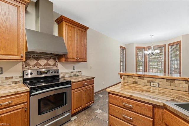 kitchen featuring a notable chandelier, butcher block countertops, wall chimney range hood, stainless steel electric stove, and tasteful backsplash