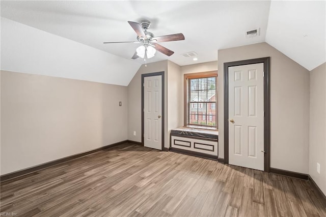 bonus room with vaulted ceiling, wood finished floors, visible vents, and baseboards