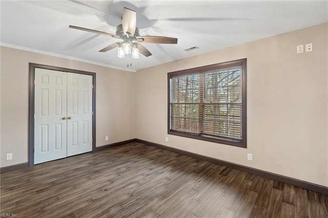 unfurnished bedroom featuring a closet, wood finished floors, visible vents, and baseboards