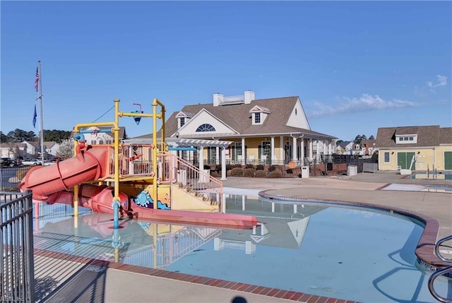 exterior space featuring playground community, a water slide, a water play area, and a patio